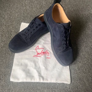 Christian Louboutin - Säljer ett par mörkblå Christian Louboutins med logga på hälen. Skorna har snörning, rund tå och är tillverkade i mocka, Pris kan diskuteras. 