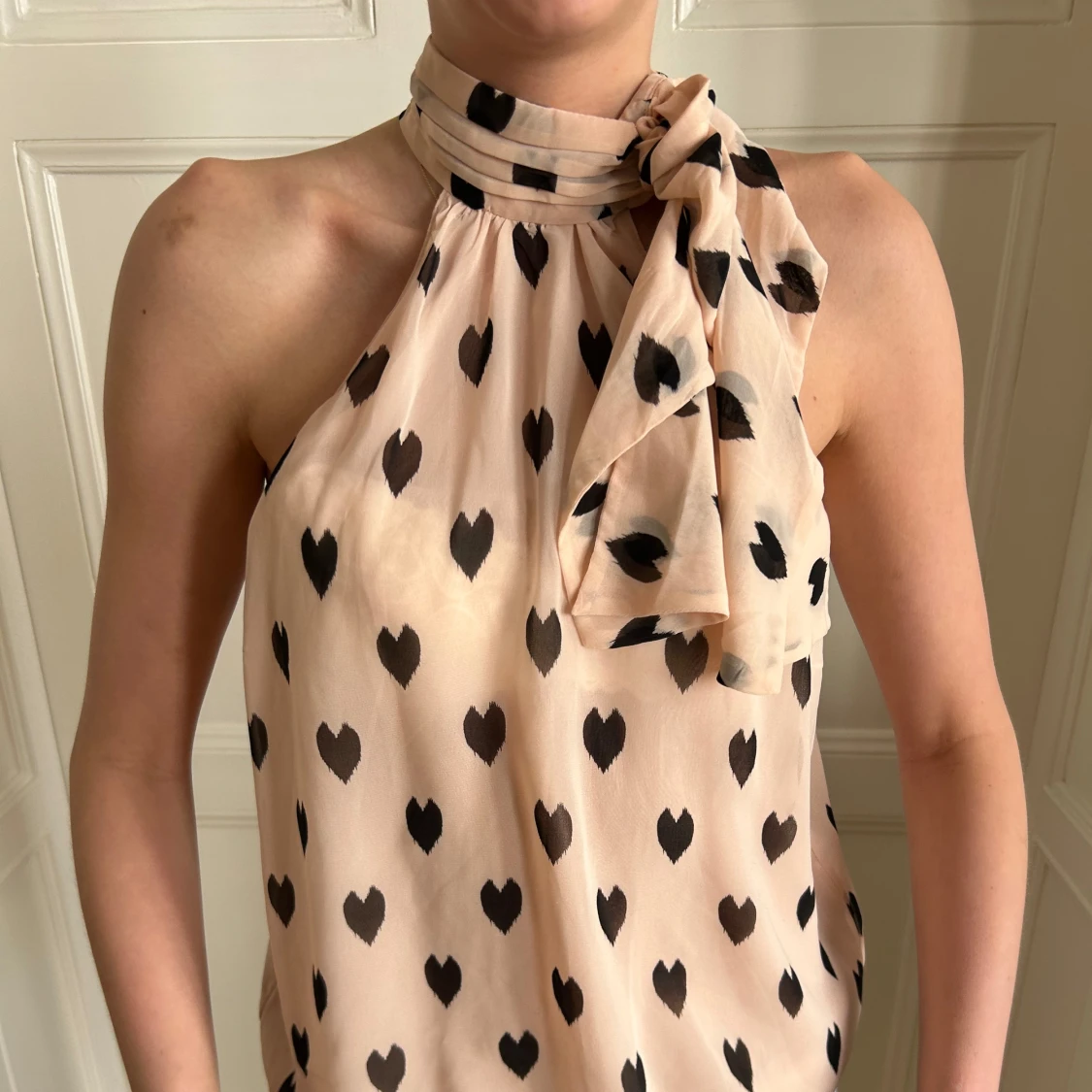 Ljusrosa halterneck blus med svarta hjärtan