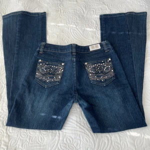 Blå bootcut jeans med broderade bakfickor från M.R. Jeans - Snygga blå bootcut jeans från M.R. Jeans med broderade och dekorerade bakfickor med pärlor och nitar. Skriv om ni har några frågor💕