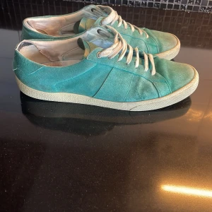 Turkosa Saint Laurent skor - Ett par riktigt snygga turkosa Saint Laurent skor.Storlek 43 passar 44 också. Dom är helt perfekta nu till sommaren. Sick 8/10 en liten defekt i bakre skon man märker inte av den när man använder skorn. Pris går att prata om. Om ni har frågor är de bara att skriva till mig .