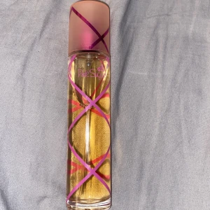 Pink Sugar Eau de Toilette 50ml - Säljer en söt och lekfull parfym från Pink Sugar. Flaskan är cylinderformad med rosa och lila diagonala linjer och har en matt rosa kork. Innehåller 50 ml Eau de Toilette med en tydlig karamell- och sockervaddsinspirerad doft.