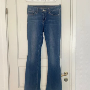 Levis 715 bootcut jeans blå - Klassiska blå Levis 715 jeans med bootcut passform. Jeansen har fem fickor, dragkedja och knapp framtill samt Levis-logga på bakfickan. Perfekta för dig som gillar en tidlös denimstil.