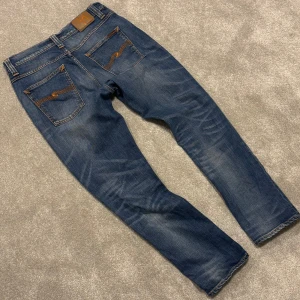 Nudie Grim Tim - Tja! Säljer dessa feta blå Nudie ”Grim Tim” jeansen med najs tvätt! Jeansen är i perfekt skick, inga defekter! Size 32/30 passar 32/32. Skriv vid funderingar!