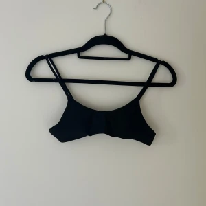 Svart kort bikinitopp - Släjer en svart bikinitopp med band i ryggen passar bra för tjejer med mindre byst.