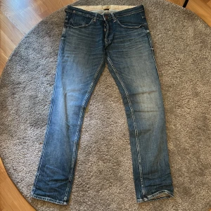 Blå slim fit jeans från Jack & Jones - Säljer ett par klassiska blå jeans från Jack & Jones, modell Slim Glenn. Jeansen har en slim passform, fem fickor och snygga slitningar för en modern look. Perfekta till vardags och passar till det mesta. Märkeslappar och tags sitter kvar.