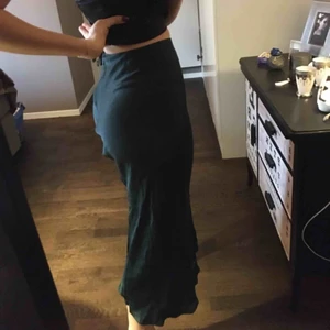  - Skogsgrön kjol i siden liknande material från Urban outfitters. Aldrig använd. Står XS men skulle säga att den är storlek S 