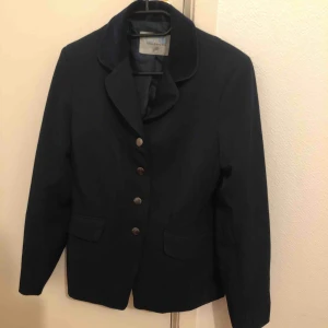 - Saknas några knappar på ena armen och en knapp bak, men den går ju att använda ändå då dom knapparna bara är prydnad, tyget är i fint skick. Mörkblå kavaj med sammet på kragen