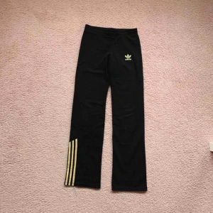  - Snygga svarta mjukisar från Adidas, med guld detalj.  Använt endast 1 gång, i bra skick! Frakt tillkommer 