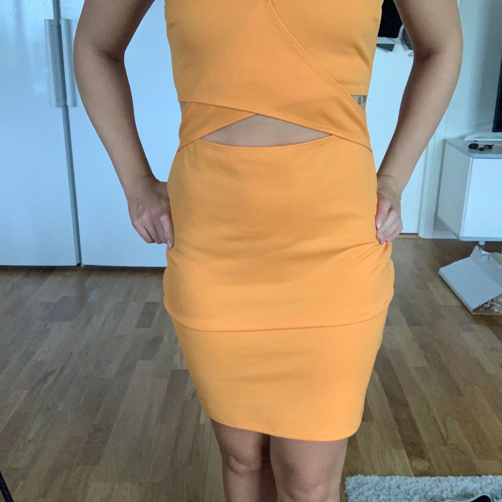 Gul/orange klänning med en liten öppning fram samt på sidorna. Storlek M (Liten i storleken) . Klänningar.