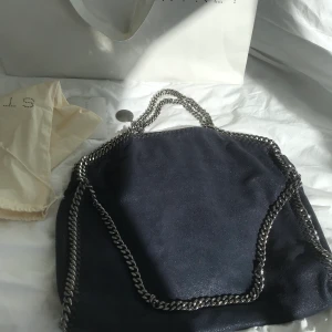 Stella McCartney väska - Säljer min älskade Stella McCartney fallabella bag. Nypris 7600kr. Väskan är i marinblått. Den är i toppskick samt kedjorna, enda skråman är en liten bläckfläck i den lilla innerfickan. Påse, dustbag och kvitto medföljer. Skriv vid intresse!💕