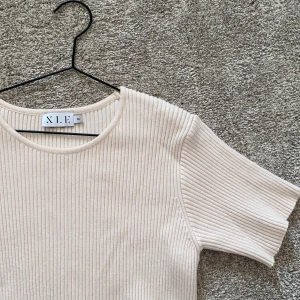 Ribbad t-shirt - En ribbad beige t-shirt från NA-KD, använd några få gånger. Väldigt skönt material. Köparen står för frakt.