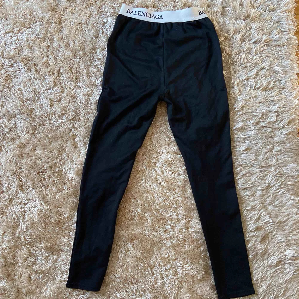 Svarta leggings, vit kant i midjan med svart text. . Jeans & Byxor.
