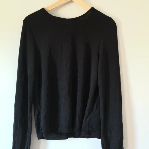 Glittrig topp - Luftig och simpel tröja, i subtilt glittrigt tyg. "volanger" nere i ärmarna och en liten urringning bak på ryggen 