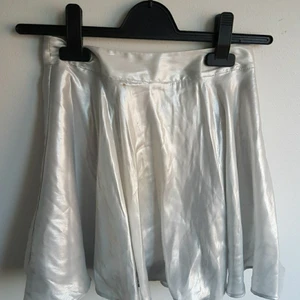 Kjol i silver - Supersöt Kjol i silver. köpt från H&M. storlek 32. Har en liten fläck (se andra bilden).