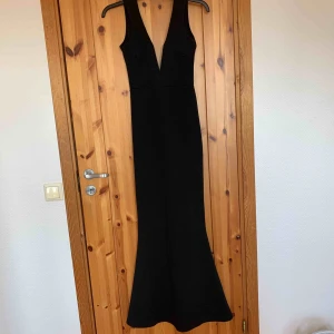  - Svart långklänning , tight med utsvängd botten. Oanvänd. Köparen står för frakten.