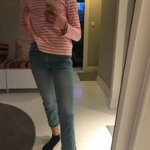  - Supersnygga ljusblåa jeans, med coola detaljer. Jeansen sitter tajt i midjan och låren med blir vida neråt vaderna! Och är rätt så korta i modellen. Anväda men inga skador!