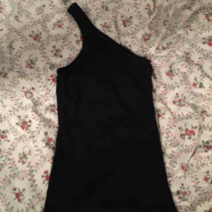  - En figurnära topp i storlek XS/S. Toppen har enbart band över en axel. •Köparen står för frakt!