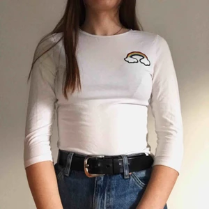 Vit tröja med regnbåge - Supersöt tröja med broderad regnbåge på bröstet, passar bra till jeans och sneakers eller med en gullig kjol.  Frakt tillkommer