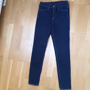 Mörkblå högmidjade jeans från H&M, finns inte längre. Storlek 25 i midjan och i längden 30, på mig som är 176 cm sitter de lite högre upp än vid anklarna. Skulle passa någon under 170! Frakt 66 kr<3