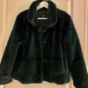 Pälsjacka  - Grön jacka i fuskpäls från Lindex. Väldigt varm och go. Inga slitningar. Köptes för 700 kr. Skulle säga att den är stor i storleken.