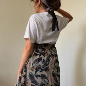 Drömmig fjäder klänning onesize  - Denna drömmiga långklänning passar både som finklänning och mer casual. Stretchig runt midjan så passar till flera storlekar. Köpt second hand. Passa på passa på!