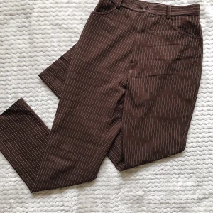 Vintage byxor!! - Säljer dessa fräna brun/vit randiga byxor i storlek 36. Köpta i en vintage butik inför en 60/70-tals fest men är därefter inte använda igen. Är förhandlingsbar med priset så kom med förslag, frakt tillkommer på 22 kr 🤍