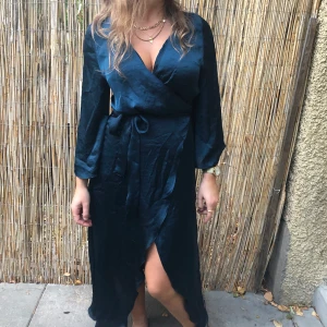 Klänning Gina tricot  - Mörkgrön klänning från ginatricot. Omlott med trumpetärm. Frakt 50 kr tillkommer.