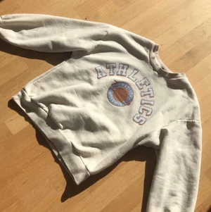 Beige sweatshirt med tryck  - Långärmad swatshirt med ett större tryck på bröstet. Använd 2-3 gånger så den är i stort sätt i nyskick.