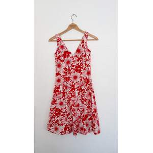 En jättefin somrig knälång klänning som är vit med rött mönster, frakten ingår!  Otroligt snygg och perfekt till sommaren. 