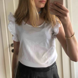  - Blus med söta volanger på ärmarna. Knappt använd.  Köparen står för frakt. Möts upp i centrala Stockholm.