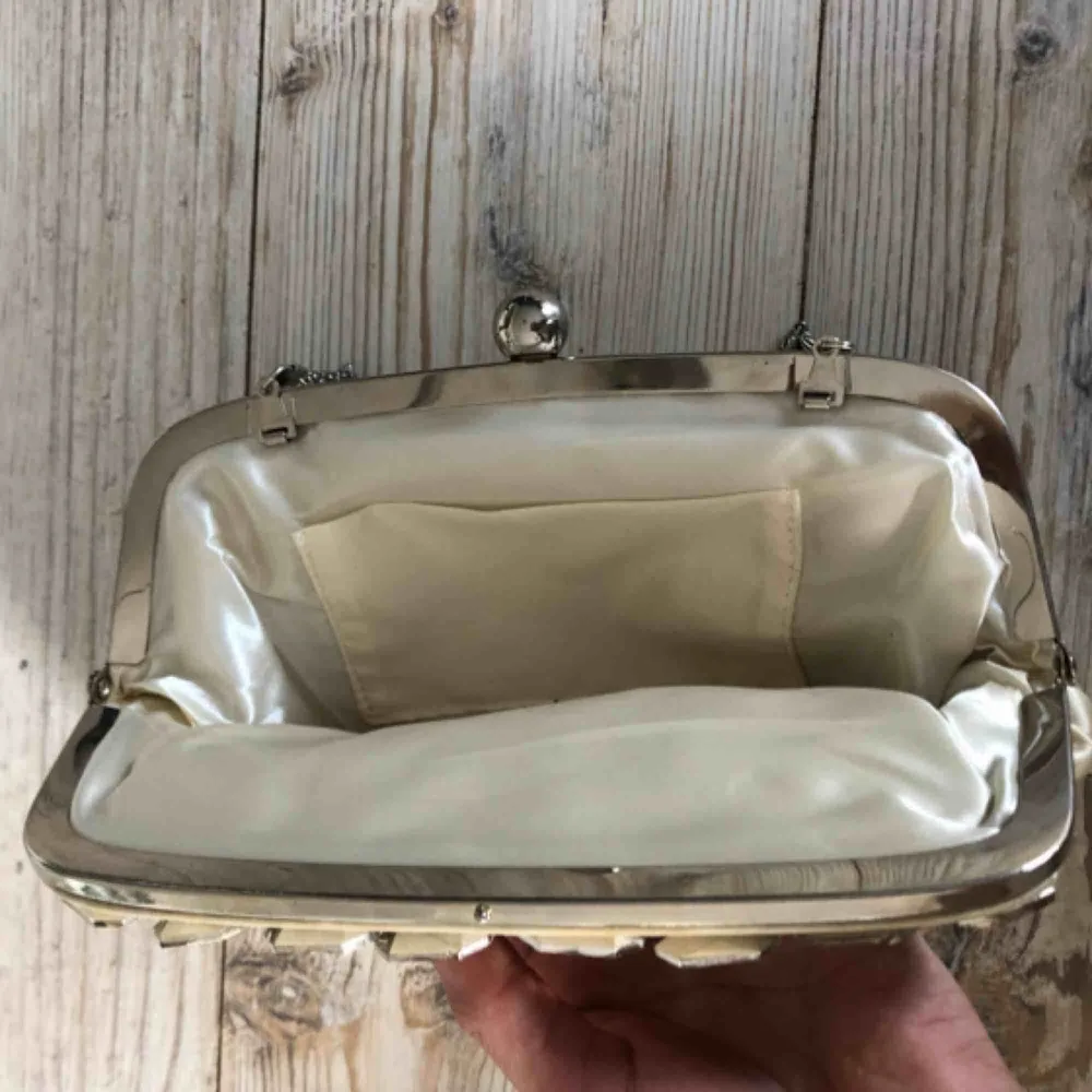 En ganska liten väska som har fina ”stenar” på framsidan och har en liten ficka inuti. . Väskor.