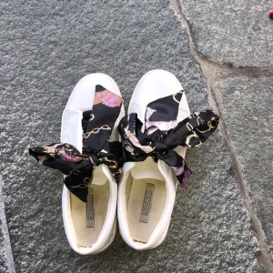 Sneakers  - Vita sneakers med detalj till snören. Fåtal gånger använda lite smuts under skorna och på sidorna. Storlek 39. 