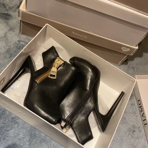 Öppna Tiamo skor - Skor från Tiamo med öppen tå och häl. Fejk dragkedja på utsidan men riktig på insidan. Använd en kort stund under en kväll.