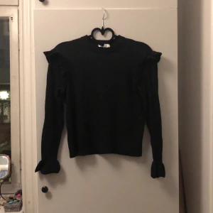 Stickad tröja  - Svart stickad tröja från & other stories! Den har ett litet hål, men det gömmer sig lixom under volangen på ena armen. Storlek S, XS.