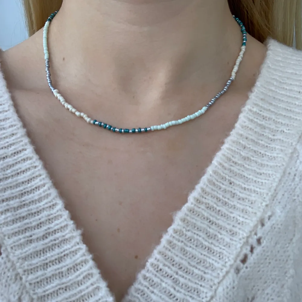 Flerfärgat pärlhalsband med små pärlor🦋🤍🥰💙⭐️💫🥳🍬💞 halsbandet försluts med lås och tråden är elastisk . Accessoarer.