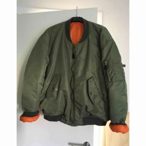  - Bomberjacka i grönt med orange foder. Säljes pga för lite plats i garderoben. Den är något oversize på mig så uppskattar strl till L/XL.  Katt finns i hem, köpare betalar frakt om de ska skickas. Kan annars mötas upp i Göteborg med omnejd. 