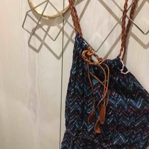  - Fin somrig, mönstrig klänning med flätade band som går att justera, mudd i midjan. Sitter jättefint på! Knappt använd 