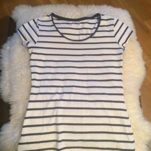  - Fin Bretagne-randig t-shirt i marinblått och vitt från MQ i jättefint skick! Knappt använd. Storlek S. Fint figursydd för en smickrande och feminin look. Ett måste i basgarderoben! :)