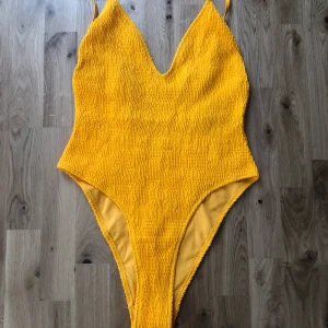 Baddräkt  - Gul baddräkt från Nelly, helt oanvänd. 