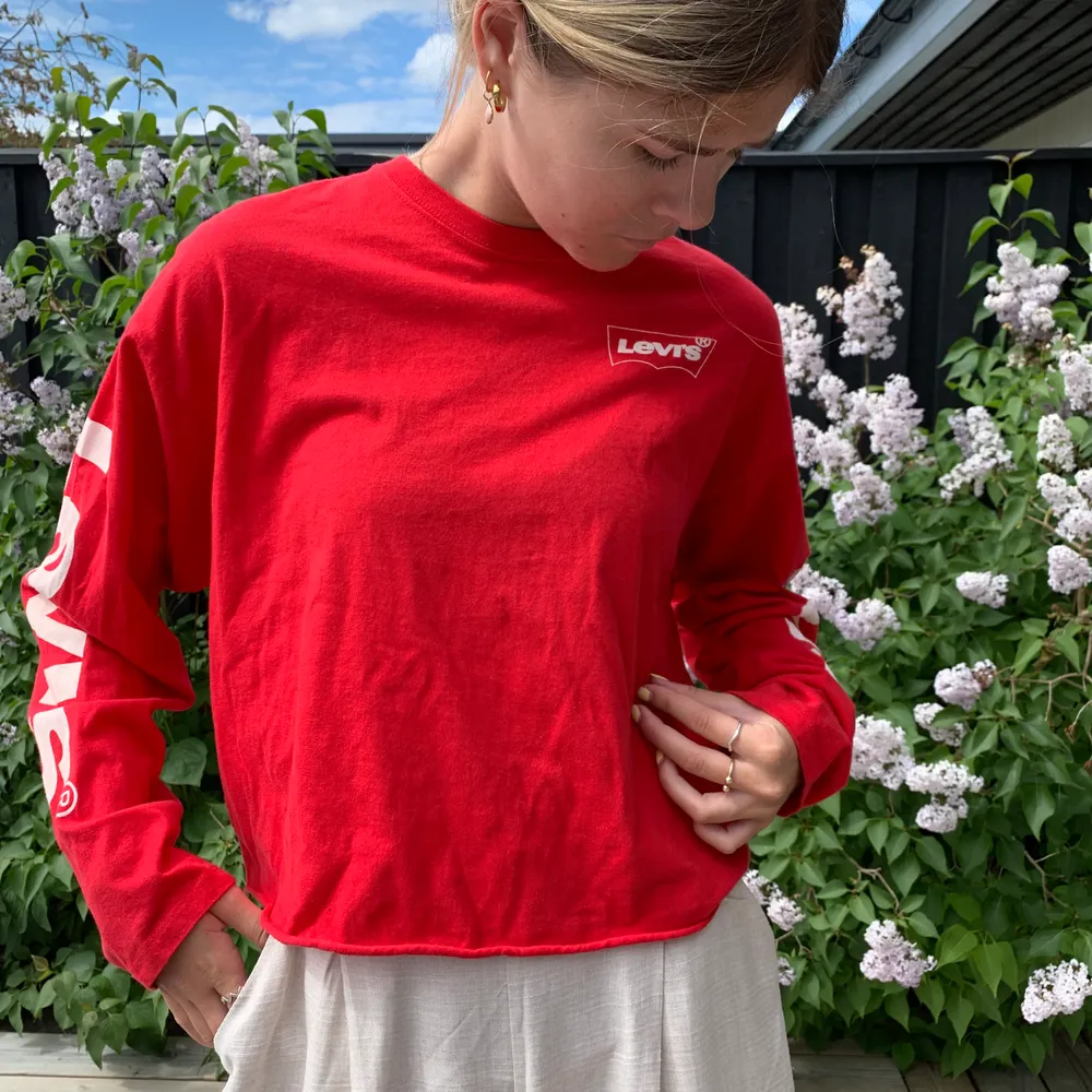 Röd kort tröja från Levis med logo på ärmar. Köpt i Österrike, inte sett i Sverige. Nypris 550kr. Toppar.