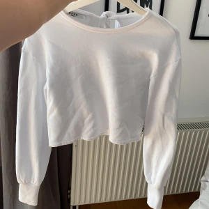 Tröja från NAKD i strl M - Vit tröja från NAKD som är kort i modellen, aldrig använd eftersom att jag föredrar lång modell. Knytes bak i nacken vilket är en fin detalj. snygga till högmidjade byxor! 