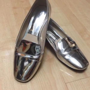 Zara silvriga flats  - Flats från Zara. Riktigt coola till kostym och gör outfiten 100 gånger ballare. Skorna har vikit sig lite vid framsidan där man går (syns på bilden) men är fortfarande i väldigt bra skick!