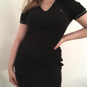 Tommy Hilfiger klänning - Klassisk snygg svart Tommy Hilfiger klänning med v formad polo urringning. Bra använt skick, storlekslappen är borta men skulle säga S/M, den är stretchig.