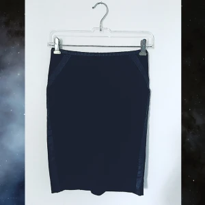 Svart Kjol med Läder - Strl 34 - En längre (går ner till mitten av låren) svart kjol med läderdetaljer längst höfterna, kommer från Gina Tricot och är i storlek 34.