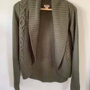 Öppen stickad kofta i storlek XS - Mjuk och behaglig med fin passform. Perfekt att slänga på sig en sommarkväll! 