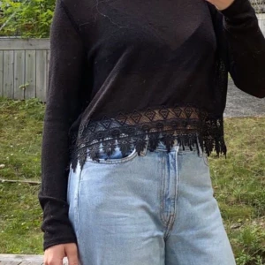 HM divided stickad tröja - Superfin stickad tröja från HM med spets nertill. En maska har gått på ryggen men annars är den i mycket bra skick! Fraktkostnad tillkommer och betalas av köparen.