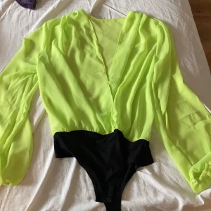 Neon grön body  - Neon grön body, ALDRIG använd. Nypris 300kr, frakten är inräknat i priset.