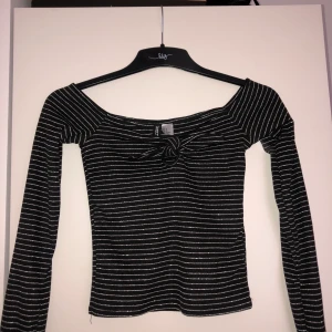 Supercool glittrig off shoulder topp!! - Använd en gång, så så fin y2k inspirerad glittrig topp med söt rosett som går att knyta upp!! Stretchigt material, storlek xs och 82kr inklusive frakt!! Perfekt till sommaren och hösten!