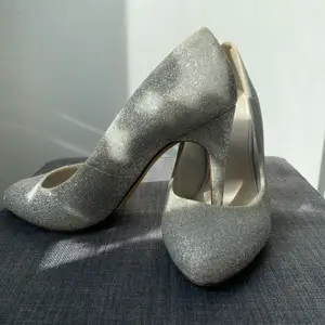 Silverglittriga skor ifrån Bianco. Storlek 39. Ändats använda  1 gång. Lite bortfall av glitter på kanten av skorna men annars fina.