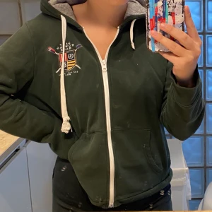 Gant hoodie - Säljer denna jöttecoola hoodien från Gant. Den är ärvd så vet ej hur mycket den är använd innan mig men av mig är den använd ett fåtal gånger för en längre period sen. Som man ser på andra bilden har den fått lite färg på sig som knappt märks och dragkedjan är även lite sliten, inte heller något jag lägger märke till. Skriv privat för mer info🥰🥰🥰